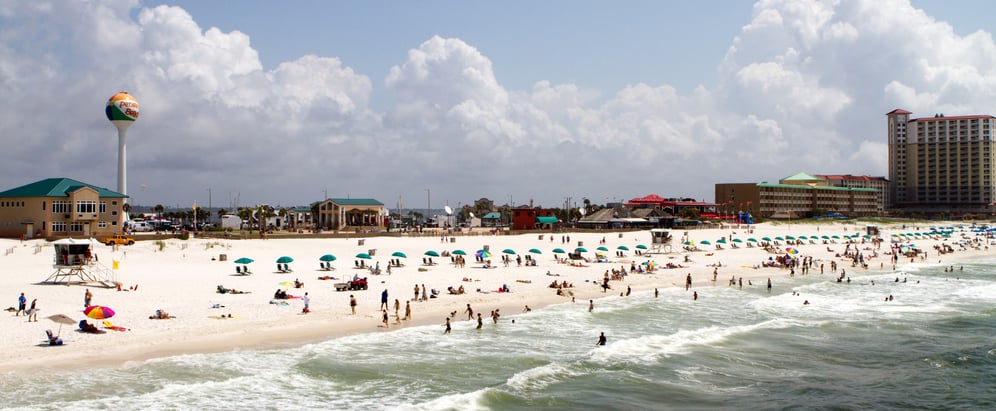 Tourists and vacationers sunbath and swim on Pensacola beach.